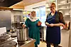 MANGE FRIVILLIGE: Dagleg leiar Marianne Bothner Kanstad (t.h.) har med seg tre faste kokkar på kjøkkenet. Frivillig Ameneh Hosaeini er ein av dei. Ho har også språkpraksis på huset og er dessutan fast med på strikkekaféen. Foto: Øystein Akselberg