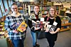 UTLÅNSTOPPAR: Katrine Thorstensen, Ingvild Elvestad Tørre og Sigrid Bjerke med bøker som var blant dei meste utlånte ved Midt-Telemark bibliotek i 2022.