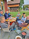 Dugnadsflokken rundt matbordet ved Eldhusveggen.
